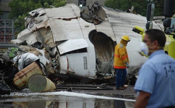 A firefighter searches the wreckage of a state-run Conviasa airline plane after it crashed into a lot used by the state-run Sidor steel foundry near Puerto Ordaz, Venezuela, on Monday.